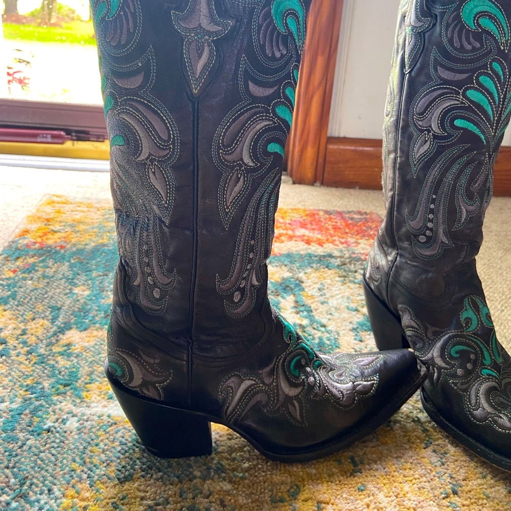 Walking boot with pointed toe, black with grey and teal detail.